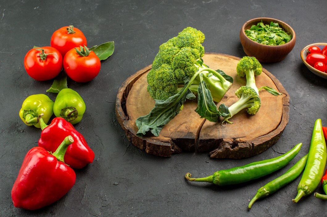 Fresh bell peppers, broccoli, and leafy greens rich in Vitamin C displayed on a kitchen counter
